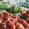 Fresh tomatoes, carrots and greens at a market (illustrative photo)