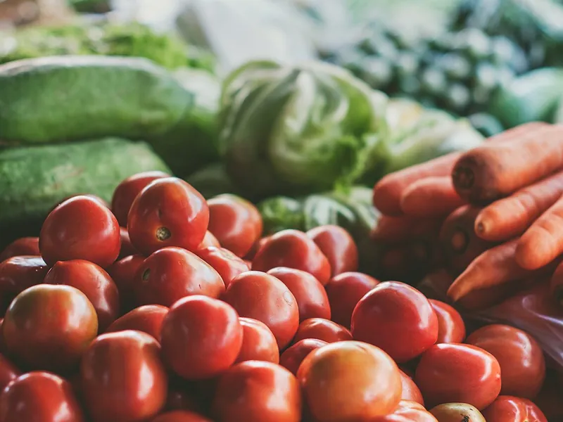 Fresh tomatoes, carrots and greens at a market (illustrative photo)